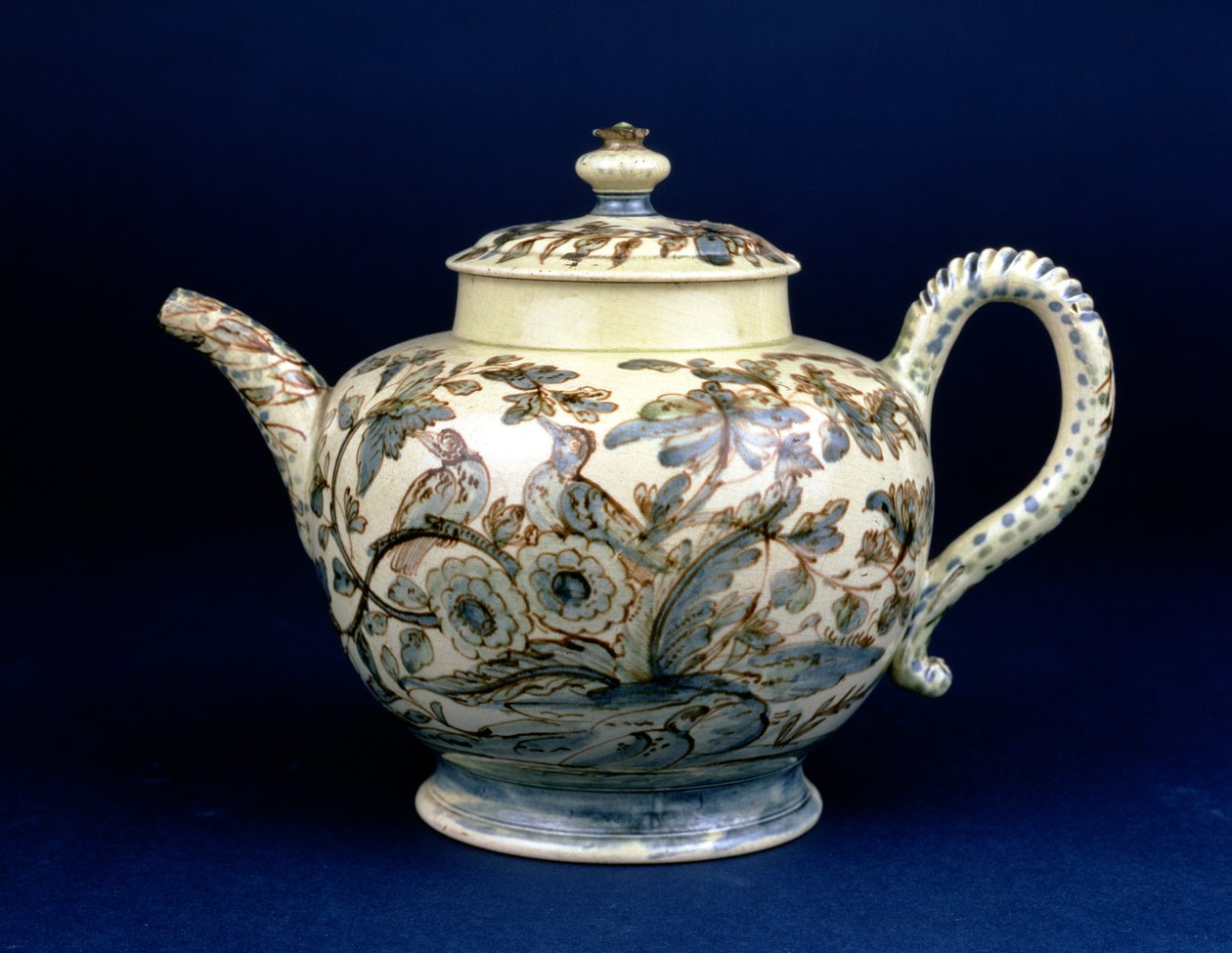 Konvička Staffordshire Creamware známá jako The Tunstall Teapot zdobená třemi ptáky v orientálním listí, malovaná nahnědlým manganem, obrys zvýrazněný modrou a zelenou podglazurní od F. Morga od English School