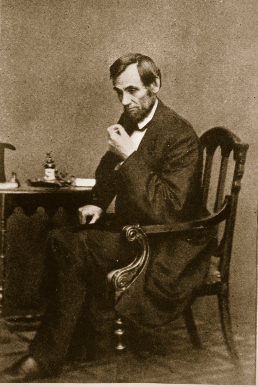 Abraham Lincoln sedí u stolu ve Washington Gallery, květen 1861 od Mathew B. Brady